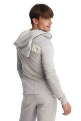 Edge form-fit crossover yoga track performance hoodie in heather grey with a small beige patch on the left shoulder