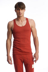 A man wearing an edge sustain tank top cinnabar in red ribbed fabric with scoop neckline and matching red pants