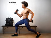 Black ergonomic dumbbells with matte finish and textured grip paired with dark blue ergowear ew1782 max bold athletic pants