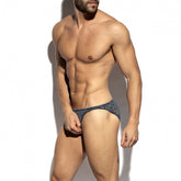 Muscular man modeling ES Collection cobalt blue metallic bloom bikini brief underwear against a white background.