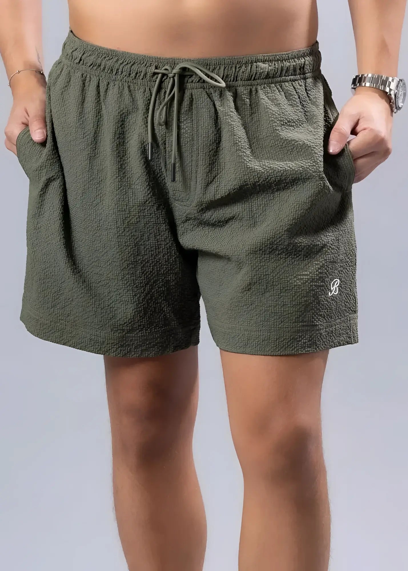 Olive green essential swim short with textured fabric drawstring waistband and embroidered logo on lower right leg