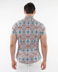 A man wearing a fauna print stretch knit short-sleeved shirt with colorful geometric and floral patterns on light background