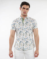 White short-sleeved stretch knit shirt with a delicate green blue and yellow floral print pattern