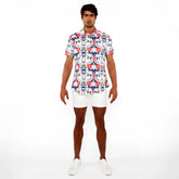 A man wearing a floral print stretch knit short-sleeved button-up shirt in red blue and green on white background
