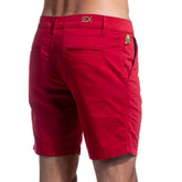 Red chino shorts with gold ex logo on waistband and green frog emblem on back pocket shown from back side