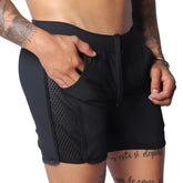 Black athletic shorts with a drawstring waistband, side mesh panel detailing, and deep side pockets.