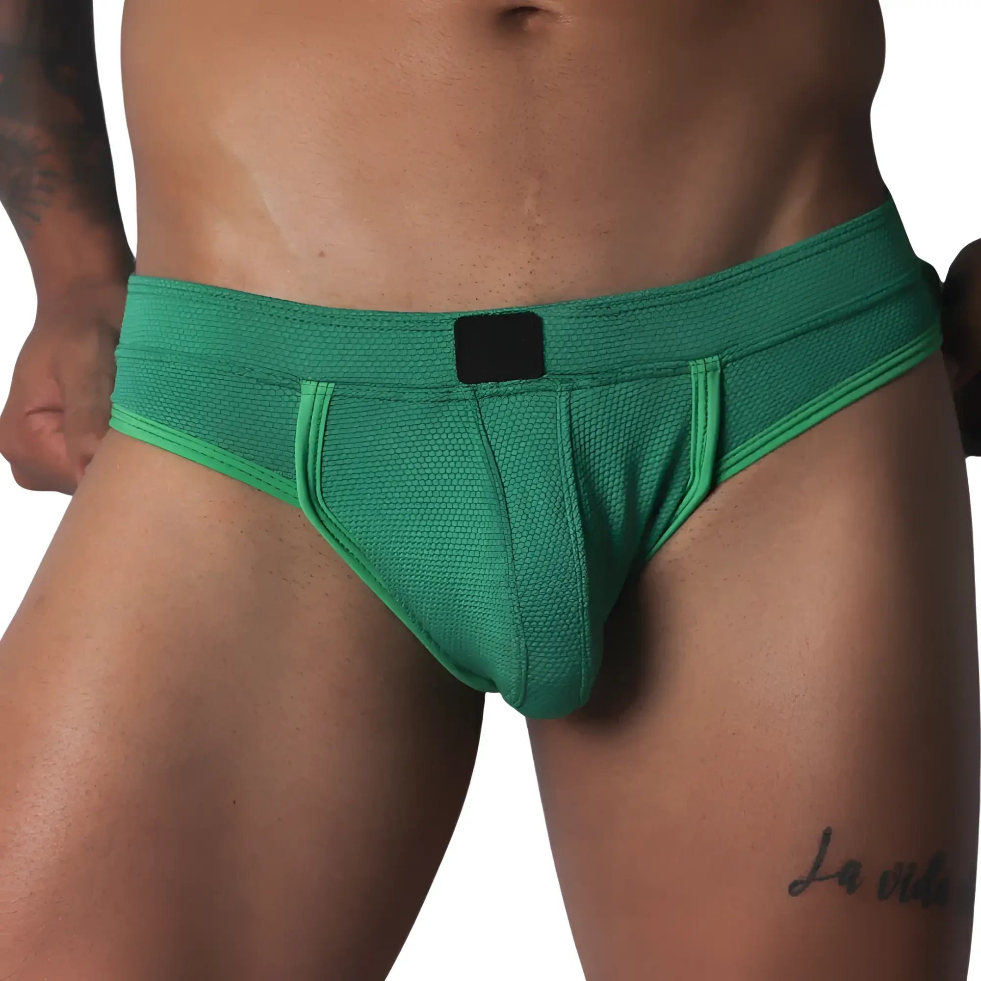 Green jockstrap featuring a textured honeycomb fabric, wide waistband, and a solid black central logo patch.