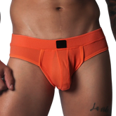 Bright orange athletic jockstrap made of textured honeycomb fabric with a solid black center label on the waistband.