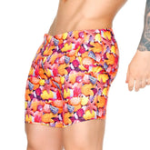 Vibrant gigo corals beachwear high-waisted swim trunks with bold seashell and starfish print in orange pink yellow and purple
