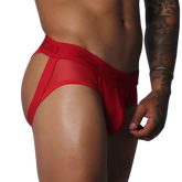 Red jockstrap thong featuring sheer mesh fabric, a pouch, and a branded elastic waistband on a muscular torso.