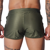 Olive green, athletic-style shorts in breathable mesh fabric with a short hem and slim fit.