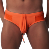 Bright orange low-rise swim brief with perforated side panels and a center drawstring with metal aglets.