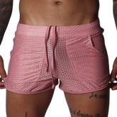 Pink mesh athletic shorts with a drawstring waistband, two side pockets, and a shorter, fitted cut.