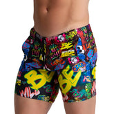 Vibrant gigo graffiti beachwear swim trunks with neon yellow green and blue graffiti pattern on black base for beachwear