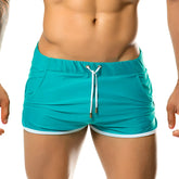 Turquoise athletic shorts with white trim and drawstring waistband for gigo hotenc green beachwear collection