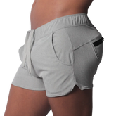 Gray short-length athletic shorts featuring an elastic drawstring waistband and a side pocket with a black zipper.