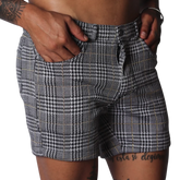 Men's slim-fit shorts in a black and white houndstooth glen plaid pattern with subtle gold thread accents.