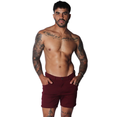 Wine-colored tailored shorts featuring a flat front, button closure, and slim-fit silhouette.
