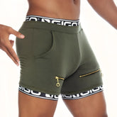 Olive green gigo tropixx athletic shorts with black and white branded waistband, side zippers, and front pocket