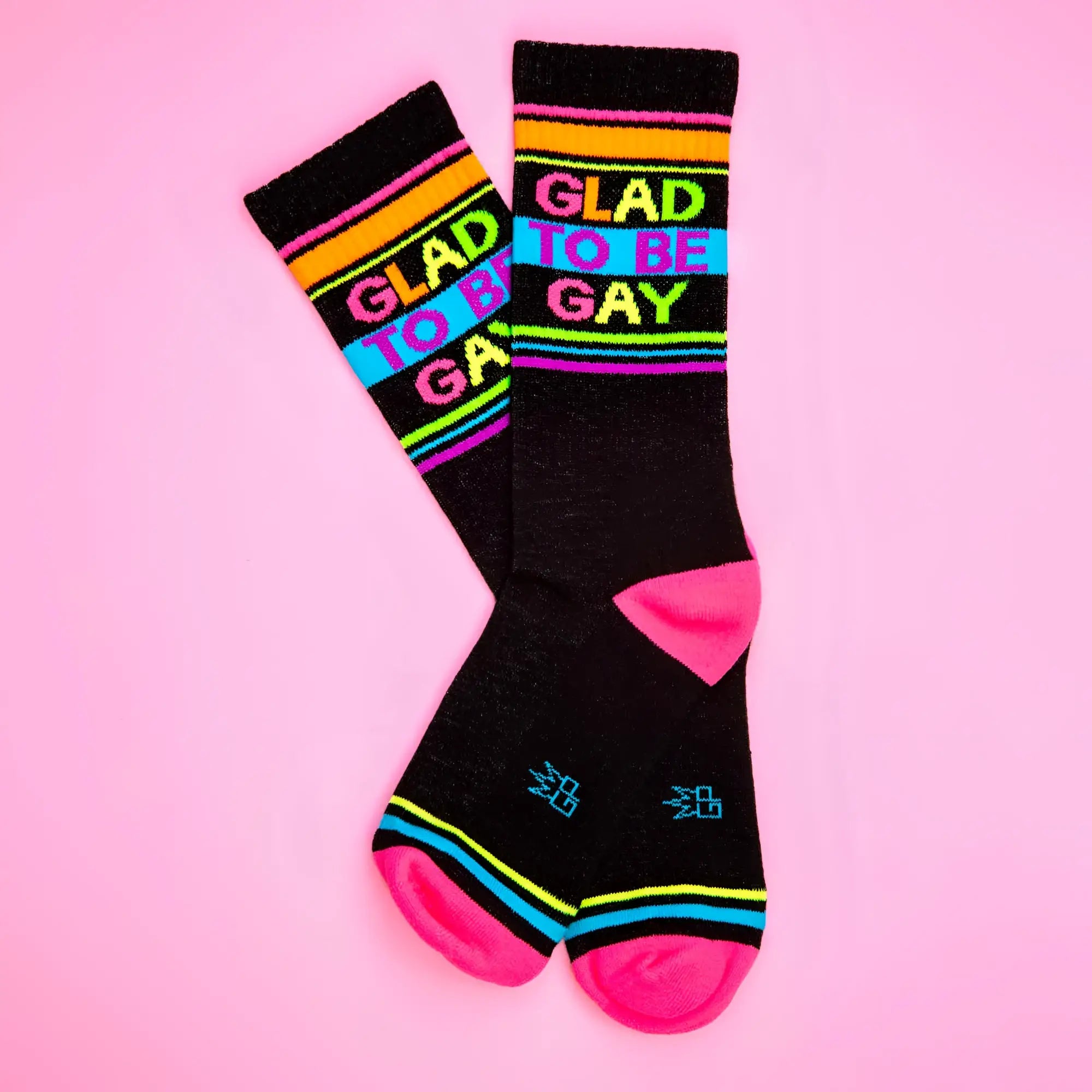 Black crew socks with vibrant rainbow stripes and bold colorful glad to be gay lettering for pride wear