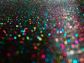 Glitter mesh tee featuring a vibrant multicolored glitter surface with pink blue gold and teal shimmering particles