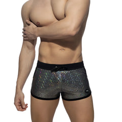 Glitter short black-trimmed swim trunks in shimmering iridescent silver holographic fabric for stylish beachwear
