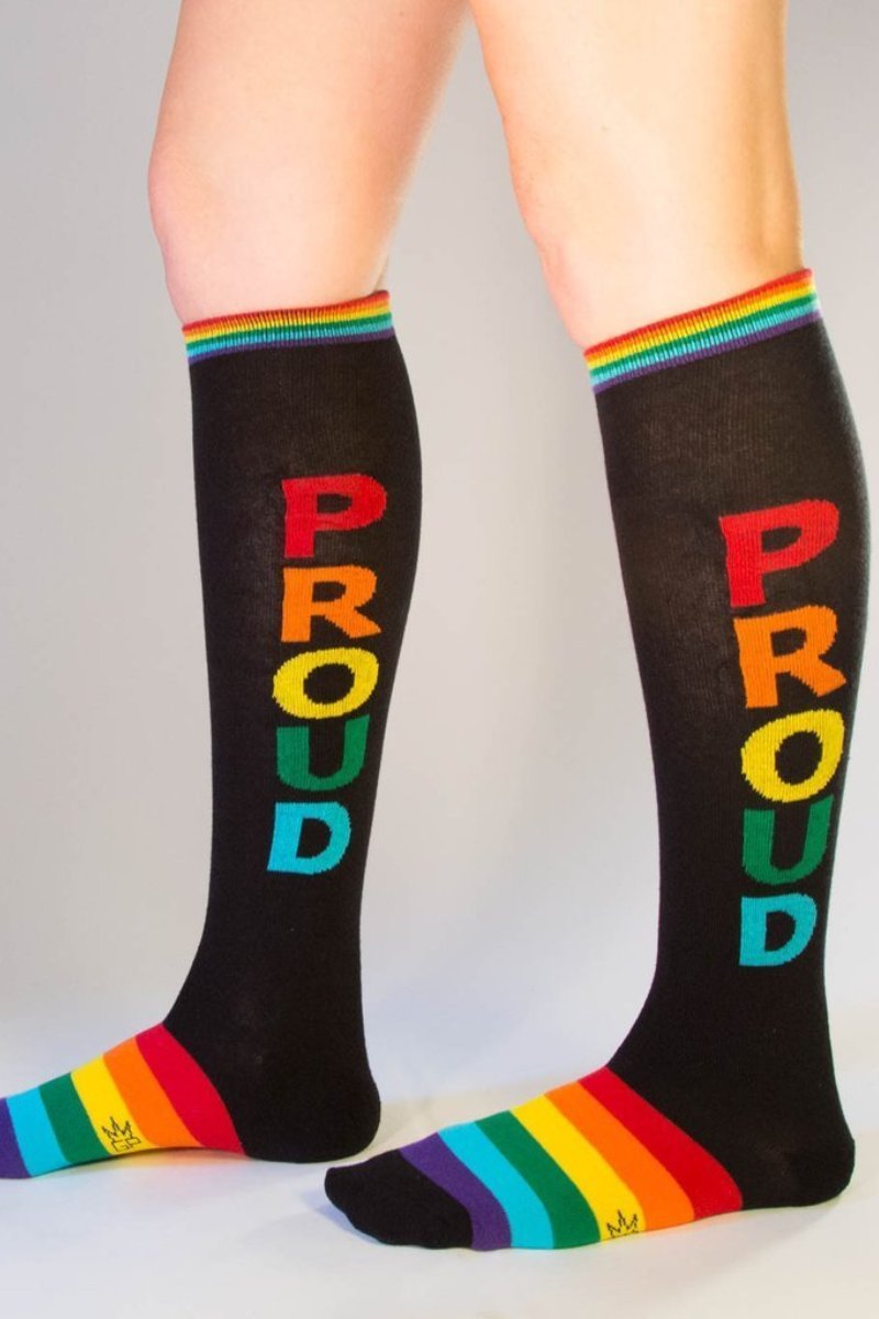 Black knee high socks with rainbow proud lettering vertically and matching rainbow striped cuff and toe