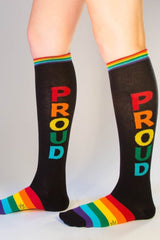 Black knee high socks with rainbow proud lettering vertically and matching rainbow striped cuff and toe