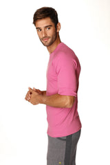 A man wearing a vibrant berry hybrid crew neck raglan tee with short sleeves and rolled cuffs