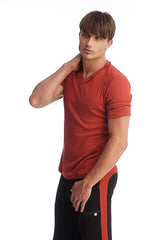 A man wearing a cinnabar red hybrid v-neck short-sleeved t-shirt with subtle seam detailing