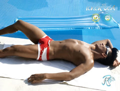 A man lies by the pool wearing icker sea eyelets square cut trunk swimwear in red with silver buttons