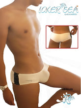 White men’s swim trunks with black lace trim on the side and a small logo near the waistband from icker sea letters