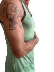 A man wearing The Perfect Tank sage green light green tank top with black trim designed for casual comfort