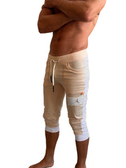 Edge cuffed yoga pants in sand with white piping featuring a drawstring waistband side pockets and logo patch on thigh