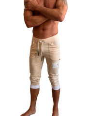 Beige capri-length edge cuffed yoga pants with white drawstring elastic cuffs and branded patch on thigh