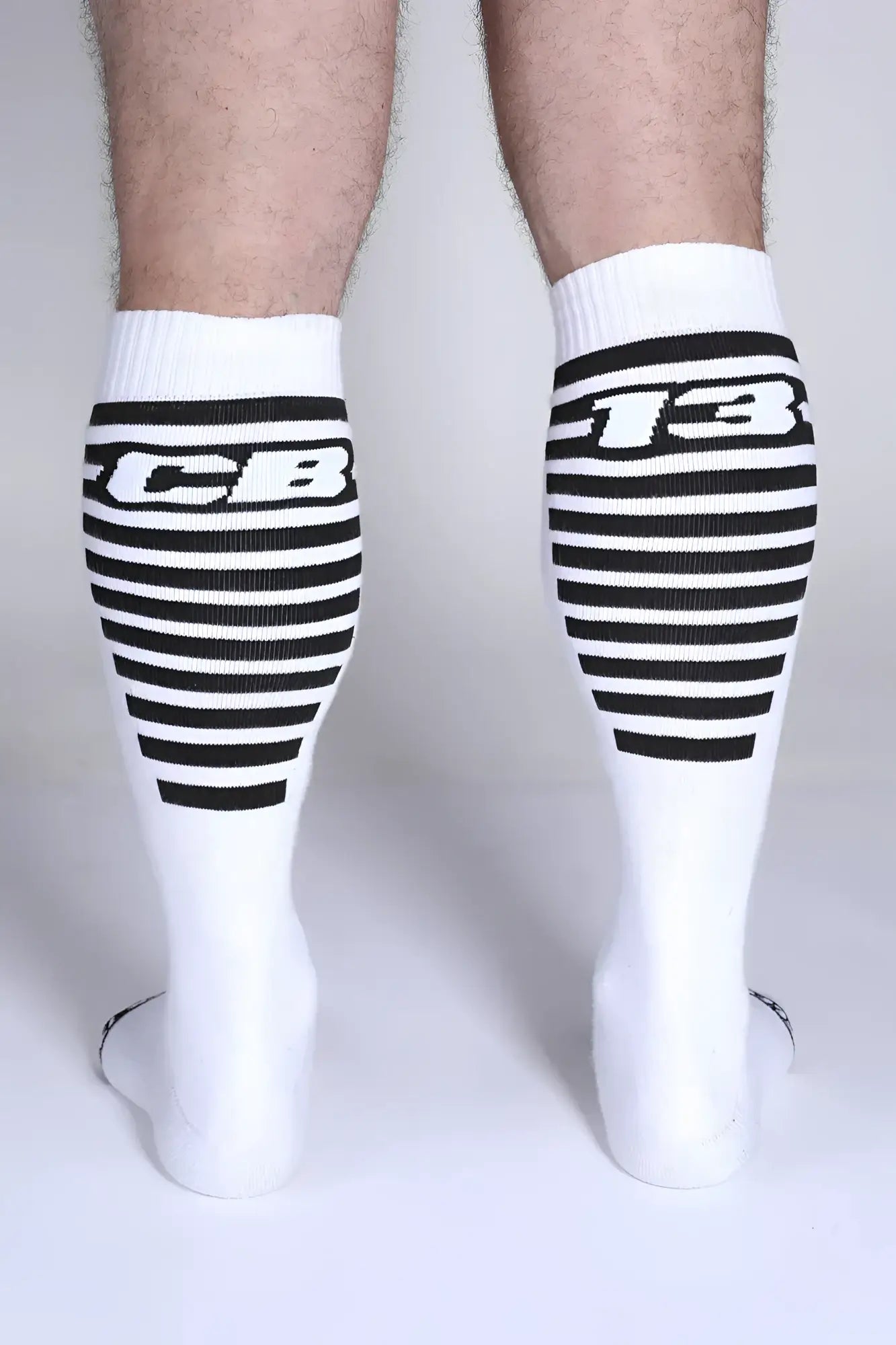 Iron grip knee high socks with white fabric black horizontal stripes and bold cb lettering on the upper leg