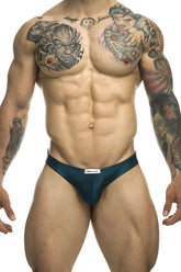 Dark teal satin briefs with a white justin simon brand tag at the waistband in classic bikini style opal green color