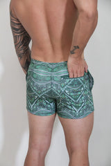Kaleidoscope shorts green patterned swim trunks with teal white and dark green geometric and tribal-inspired designs