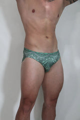 Green patterned kaleidoscope swim brief with intricate white geometric designs for swimming and beachwear