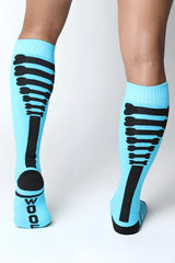 Light blue kennel club bones knee high socks with black skeletal ribcage design and wool print on the heel