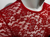 Close-up of a red lace t-shirt on a mannequin, showing the floral pattern and crew neckline.