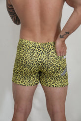 Yellow leopard-print fleece shorts with snug fit and small gray reflective patch on the side for casual wear