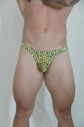 Bright yellow leopard swim thong with black spots in a stretchy fabric for stylish beachwear