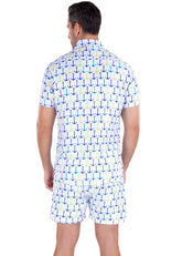 A man wearing a white life’s better on a boat short-sleeved shirt and shorts with blue teal and light green anchor patterns