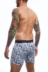 White boxer briefs with a black waistband featuring barbershop themed skulls glasses and razors pattern by malebasics
