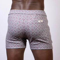 Back view of gray and white mandala linen texture shorts with repeating circular design and brand tag on waistband