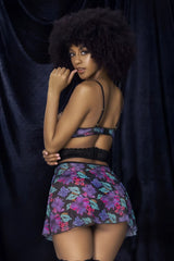 A woman wears a Mapale 7496 babydoll three piece set with black lace bra and floral mini skirt in vibrant colors