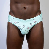 Mint green martini swim brief with playful pink martini glass pattern and black outlines for swimwear use