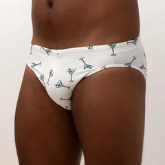White martin swim brief swim trunks with teal martini glass pattern and black outlines perfect for beachwear