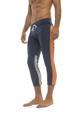 Mens navy blue athletic capri yoga pants with orange and white side stripes and 4/5 zipper pockets